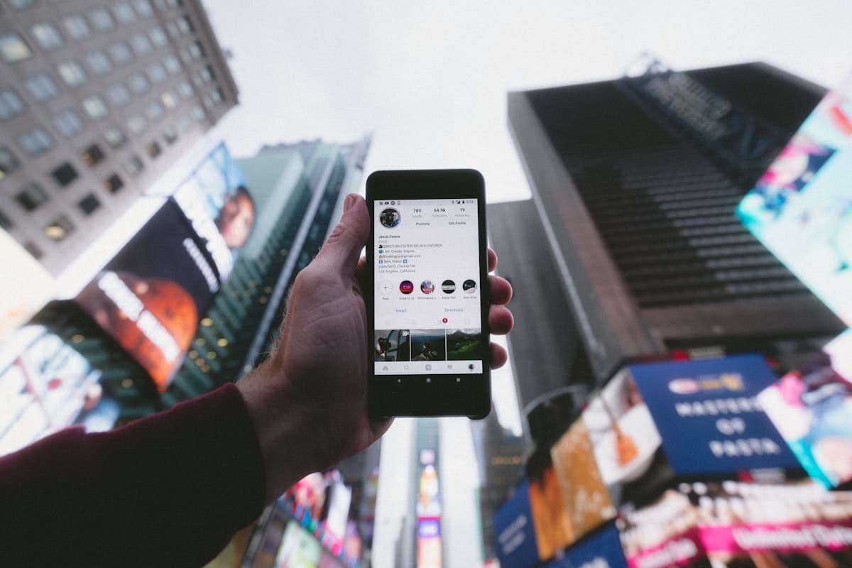 A creator holding a phone in a city setting, reflecting phone-first social selling